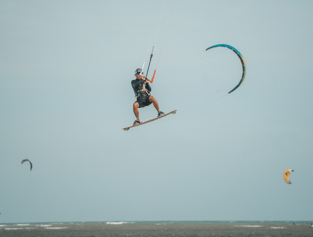 a man flying through the air while riding a kiteboard