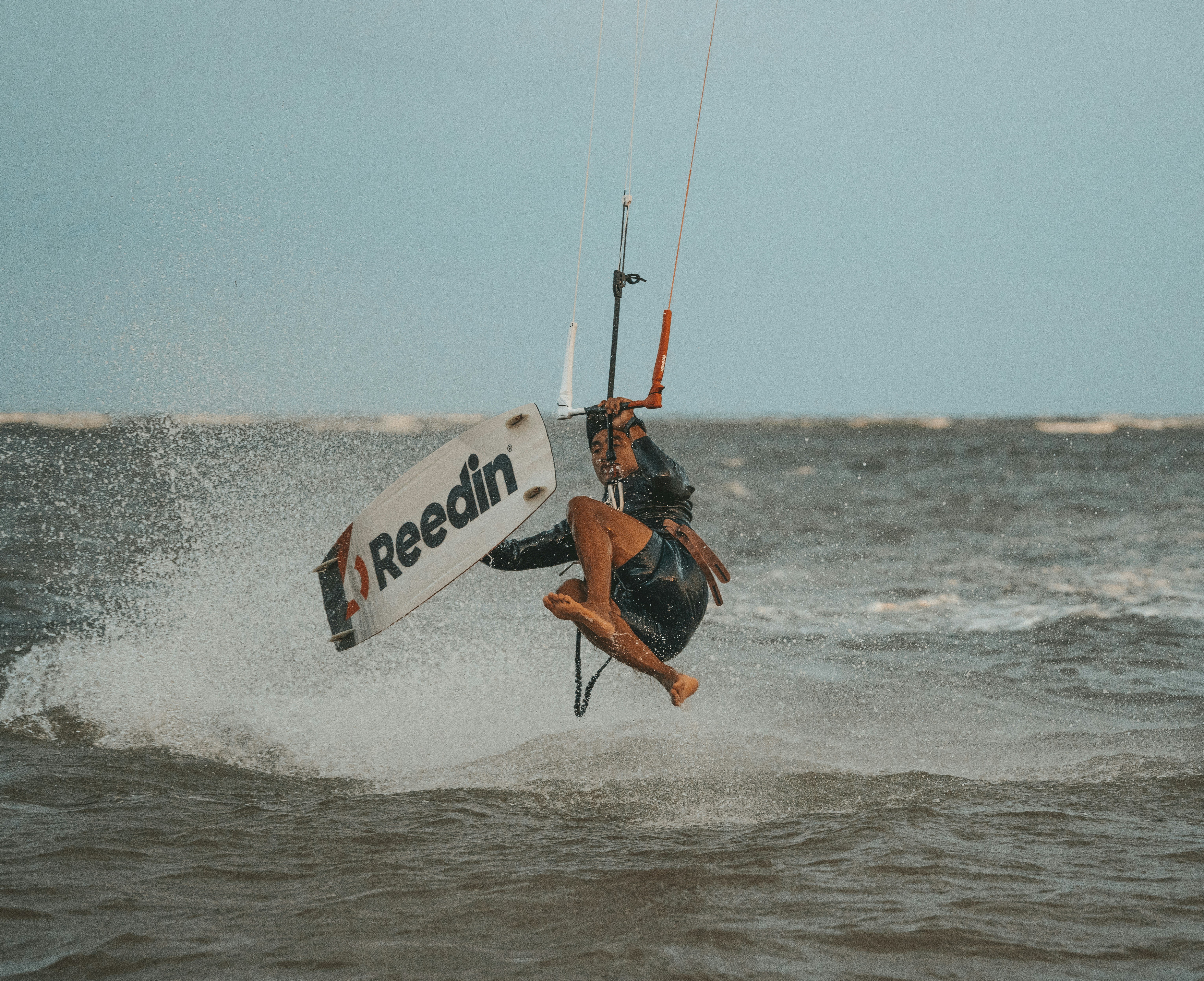 a man riding a surfboard on top of a wave