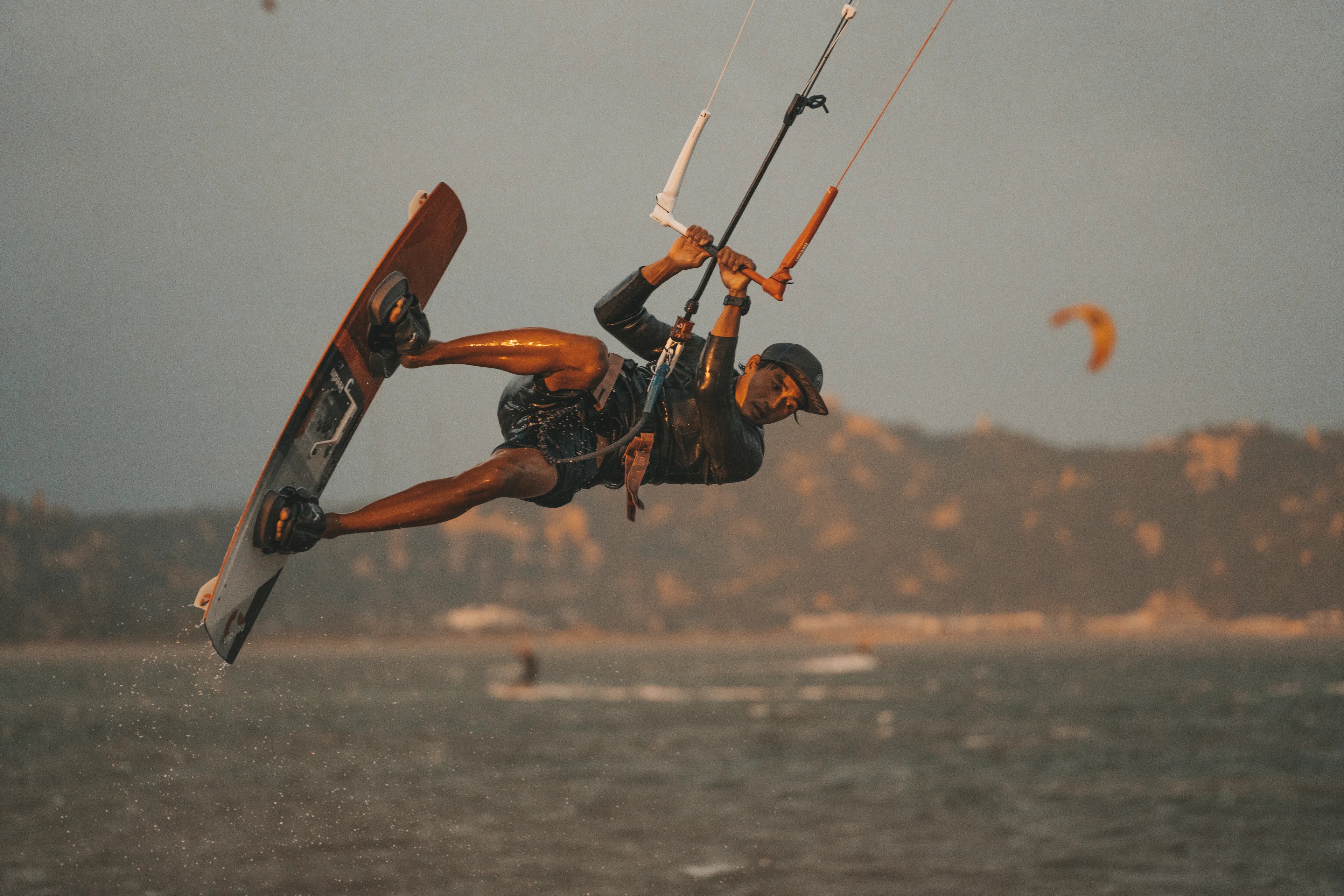 Kiteboarder riding across turquoise coastal water