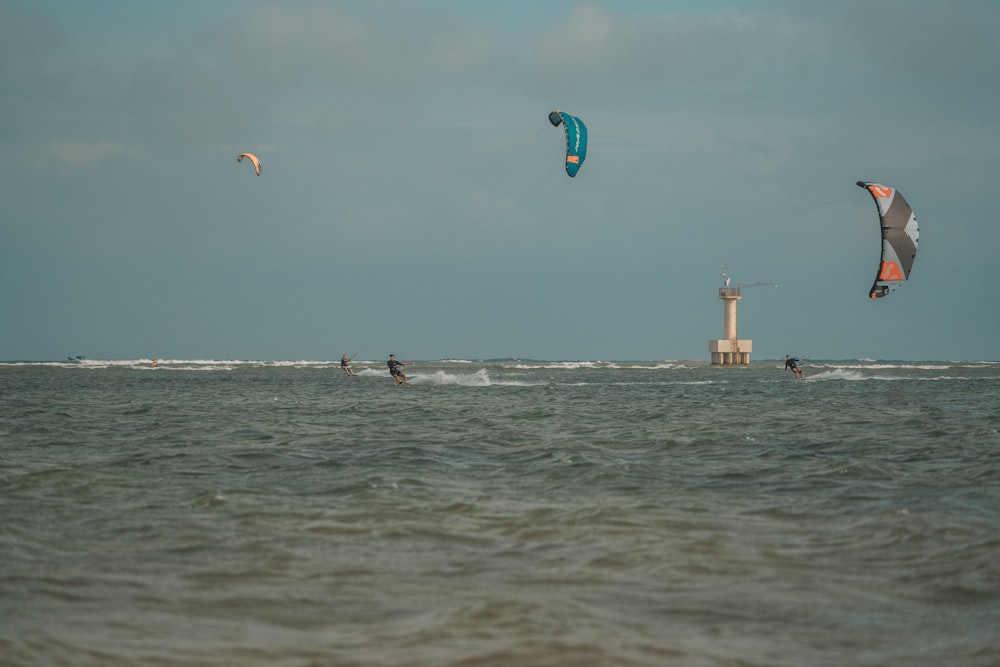 a group of people kite surfing in the ocean