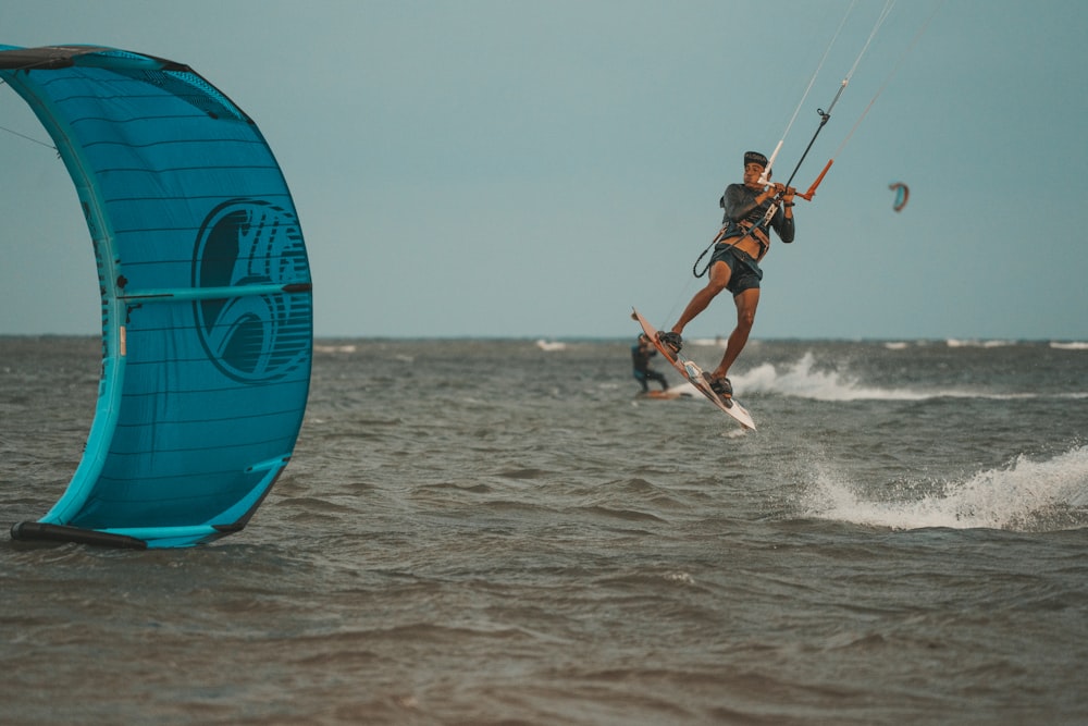 a man riding a kite board on top of a body of water