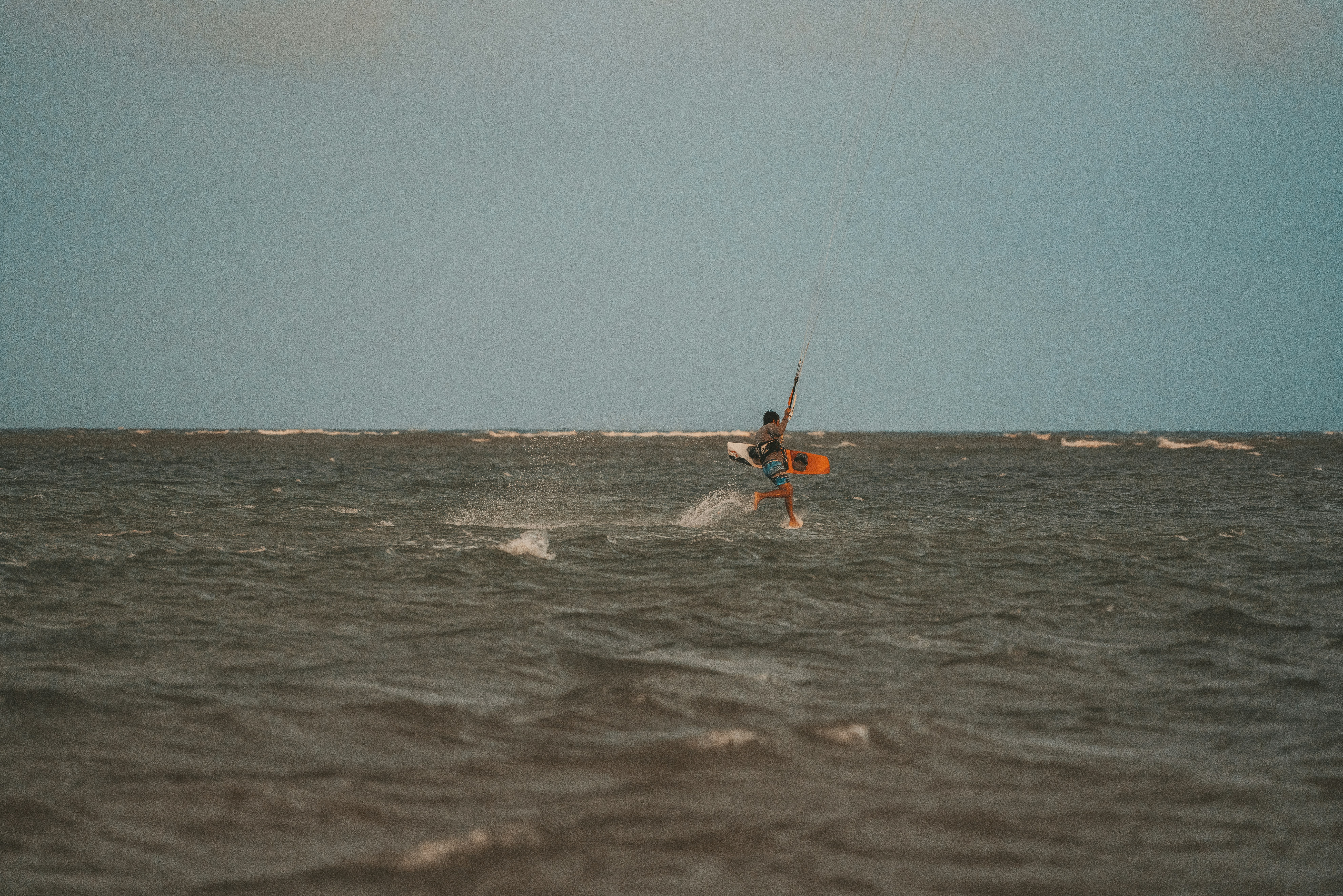 a man riding a kiteboard on top of a large body of water