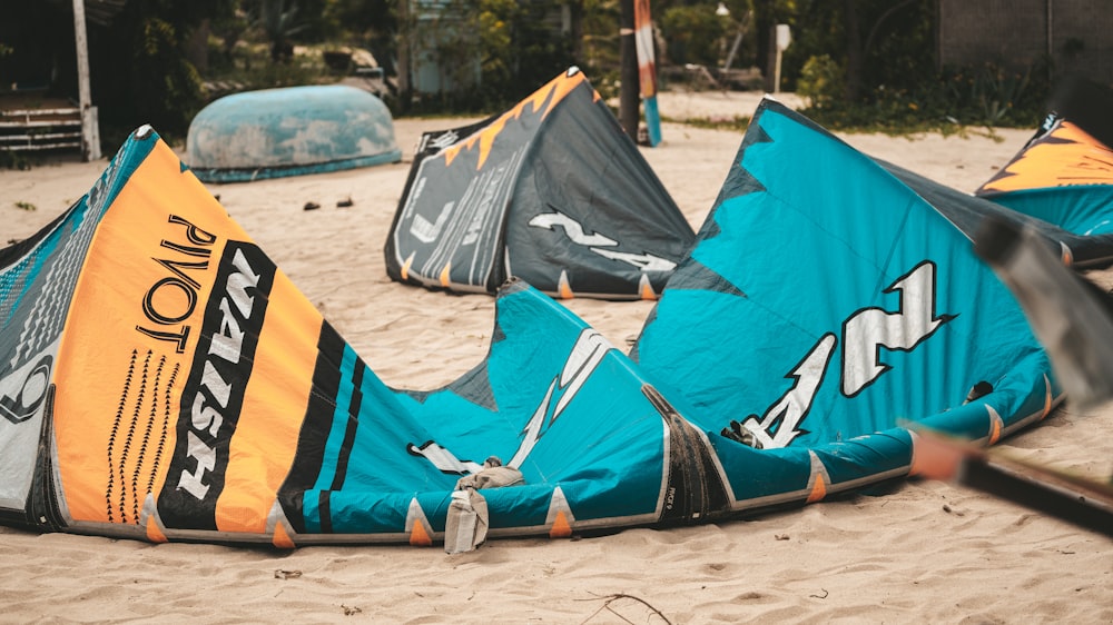 a group of kites laying on top of a sandy beach