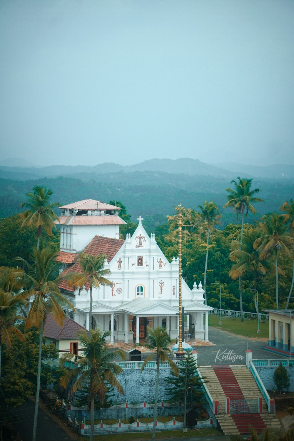 a large white building surrounded by palm trees