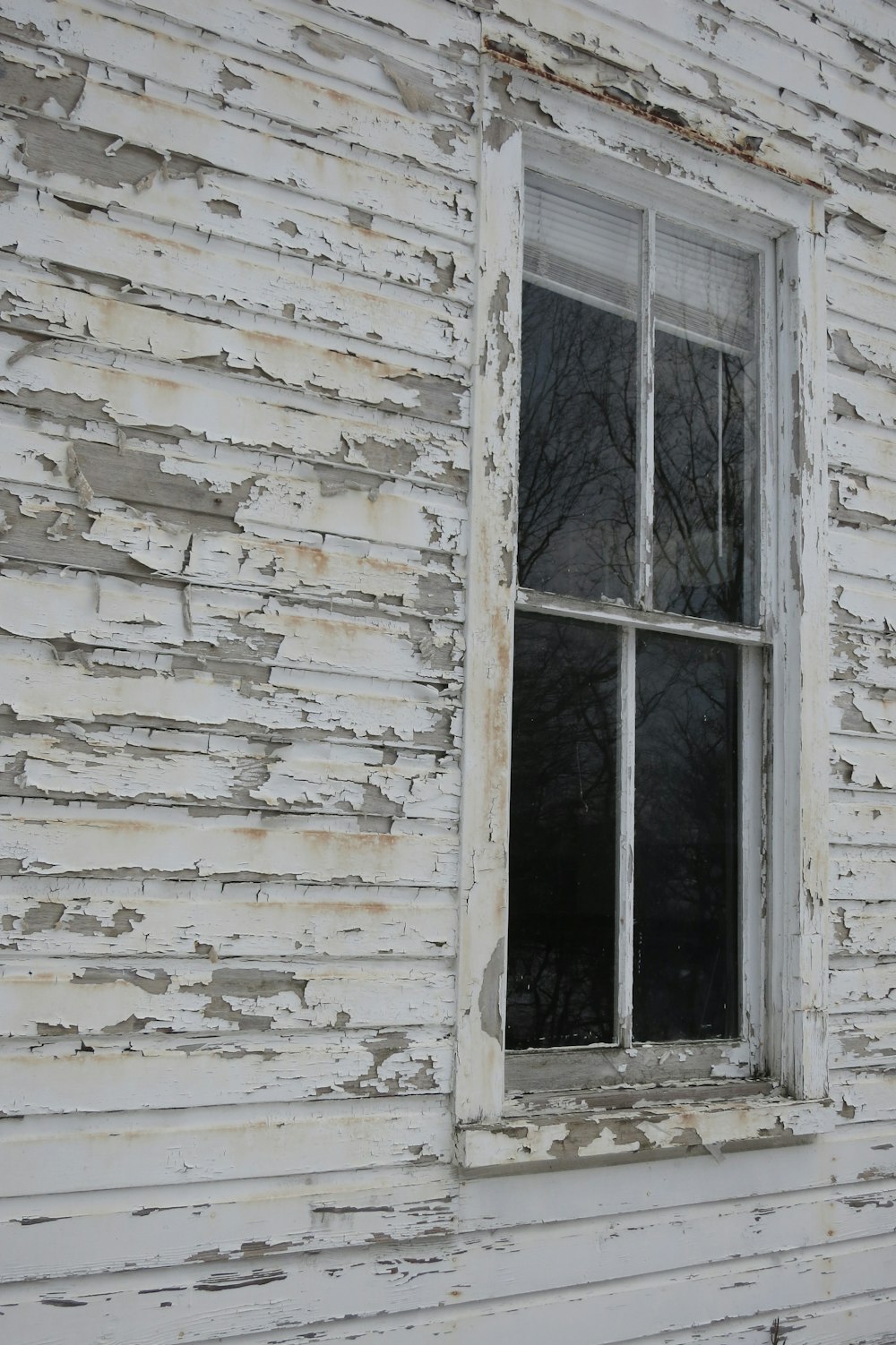 an old white house with a broken window