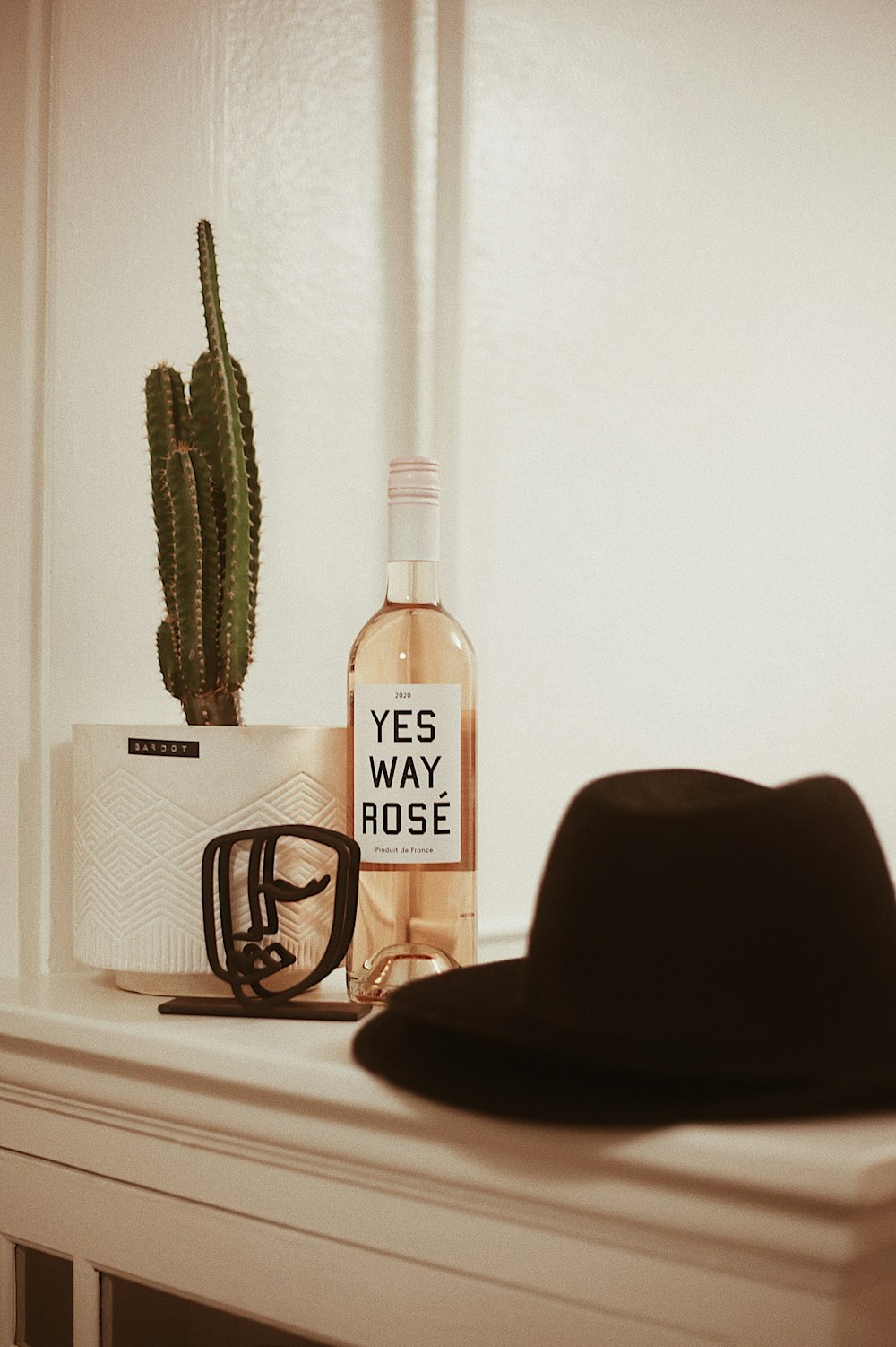 a bottle of booze next to a hat and glasses