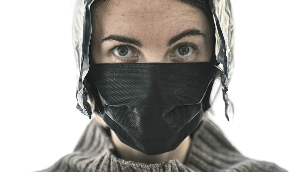 a woman wearing a black mask with feathers on it