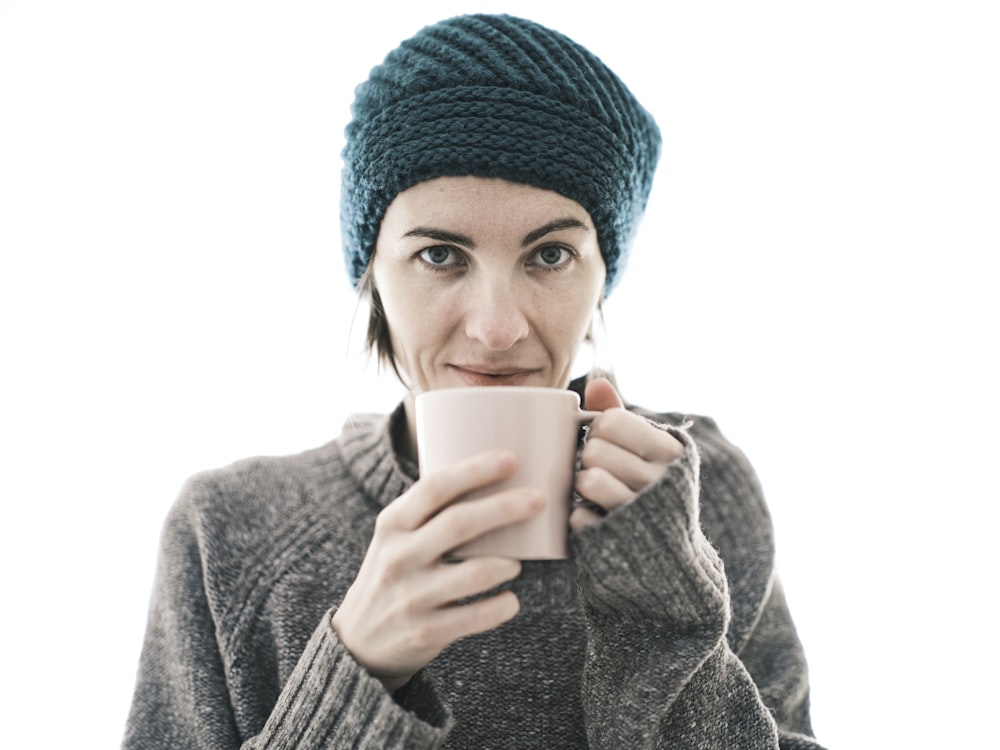 a woman is holding a cup of coffee