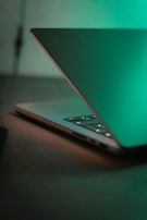 Open laptop on a wooden table with subtle wood grain texture, blending tech and nature.