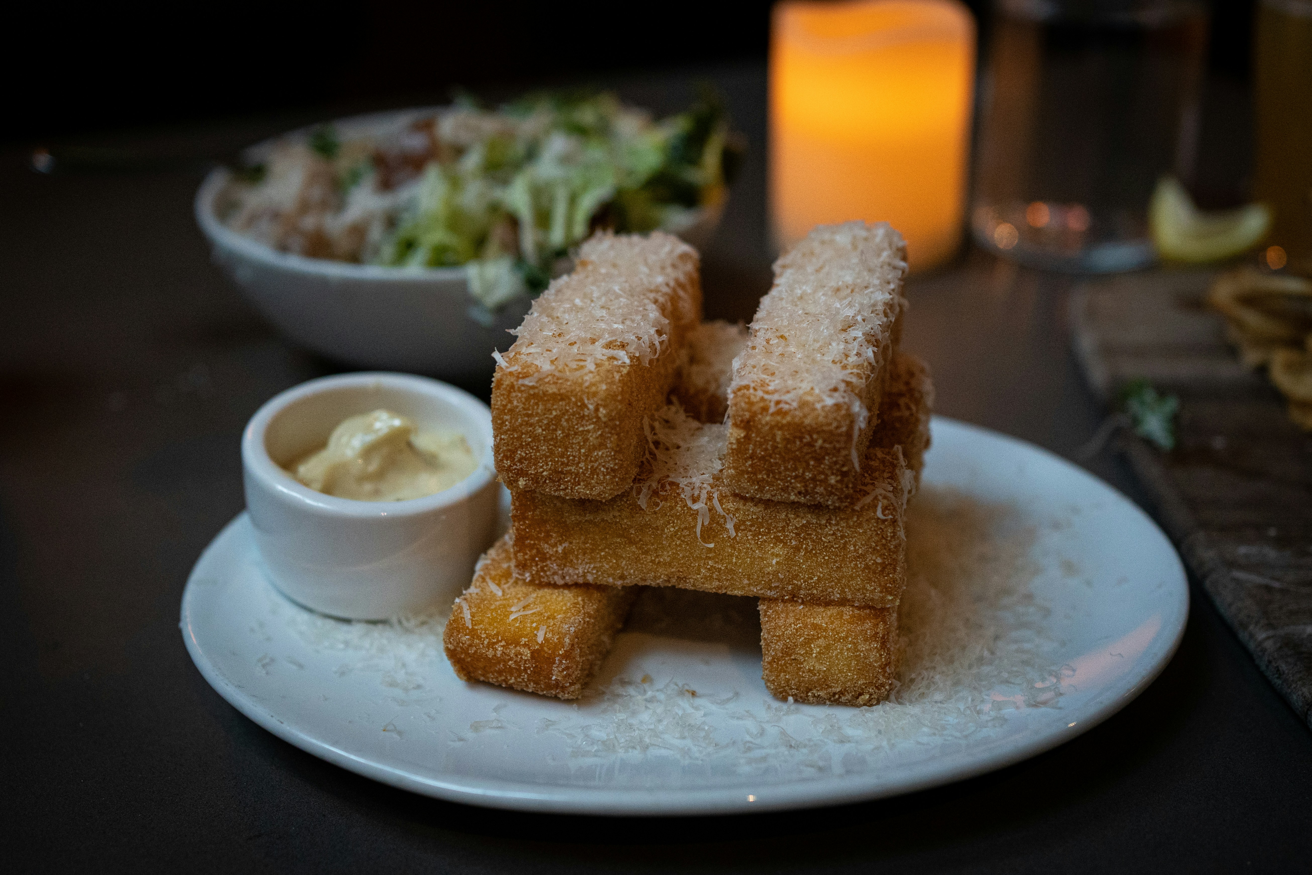 a white plate topped with food next to a bowl of salad, Polenta fries from Victor Tavern in Seattle, Washington