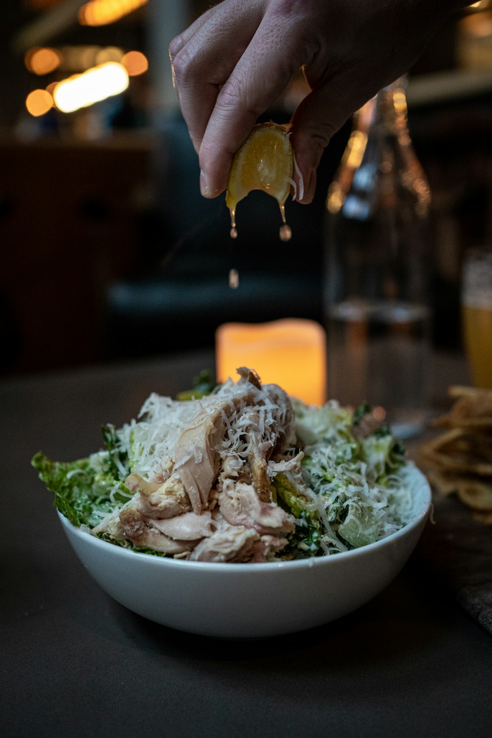 a person is squeezing a lemon into a salad