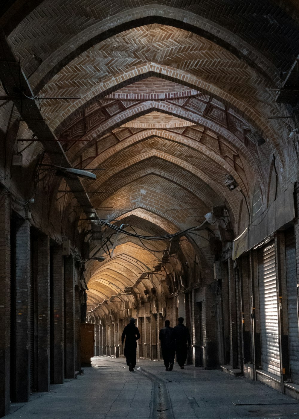 a couple of people walking down a long hallway