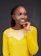 a woman in a yellow top posing for a picture