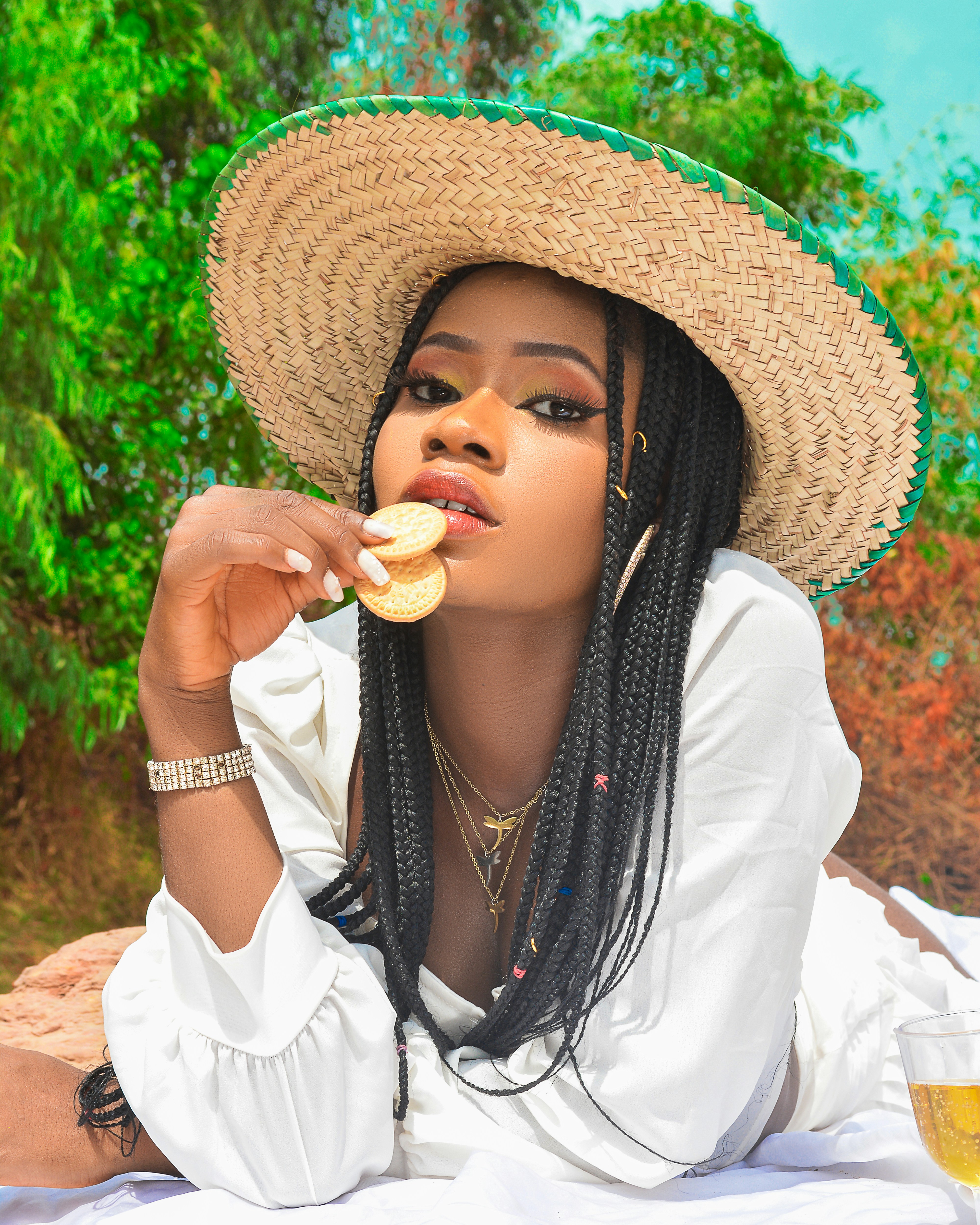 a woman wearing a straw hat eating a donut
