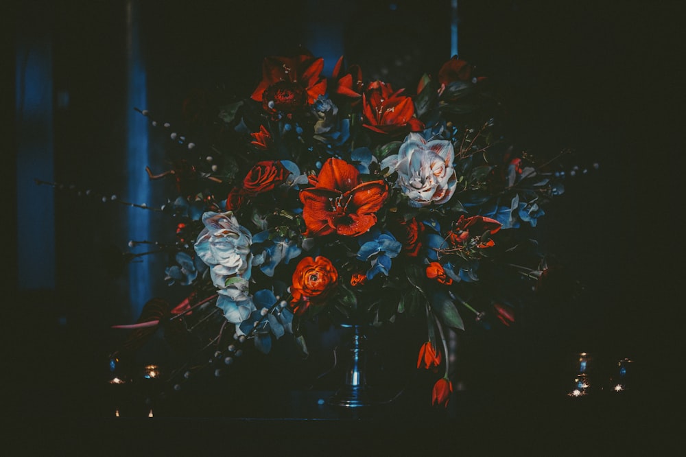 a vase filled with lots of red and blue flowers