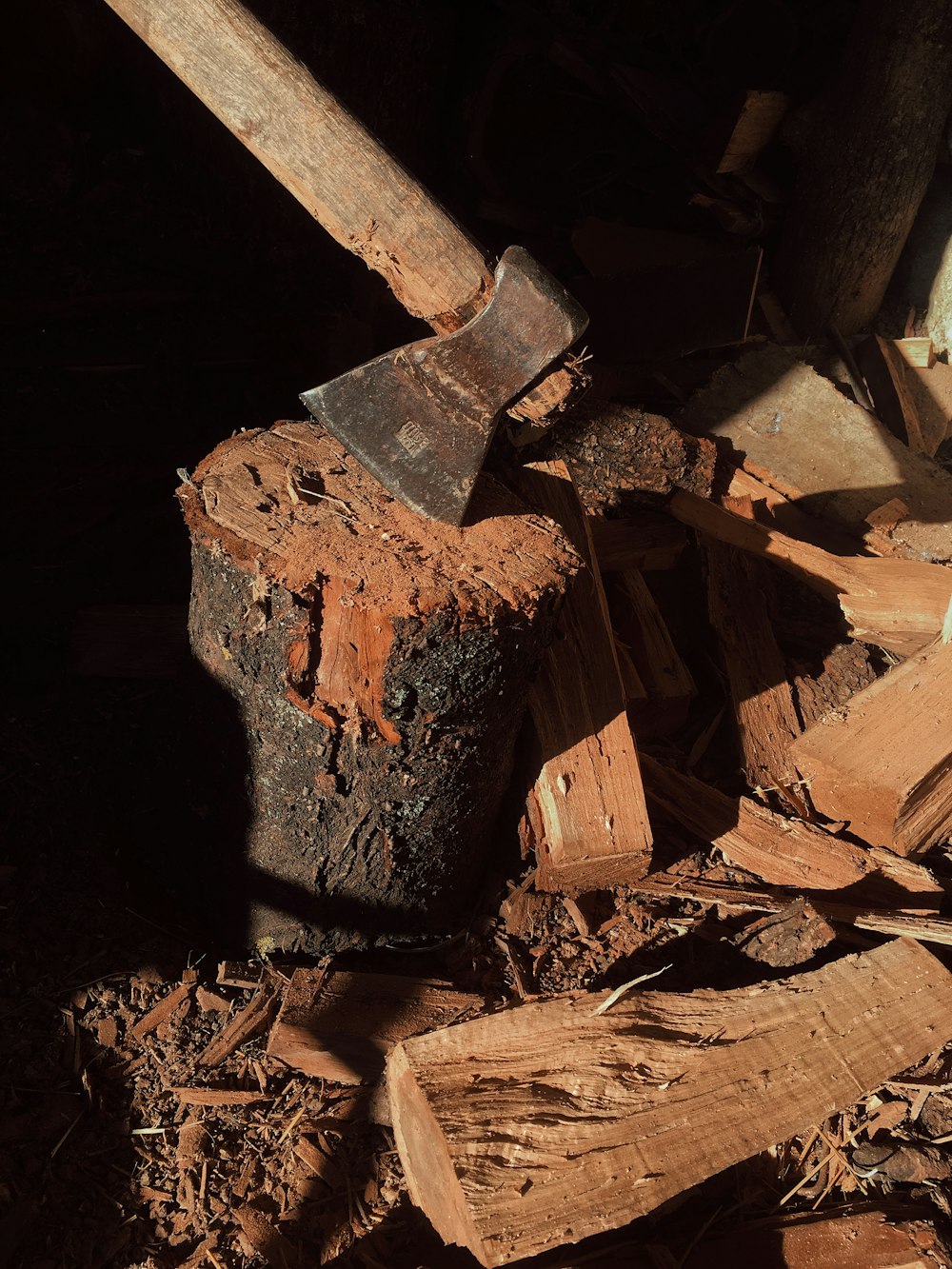 a large axe is stuck in a pile of wood