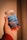A hand holding a bottle of Simply8 Gummy Vitamins, specifically Vitamin D3 with a dosage of 2000 IU per serving. The bottle is blue with a white lid and contains 60 gummies with orange, lemon, and strawberry flavor.