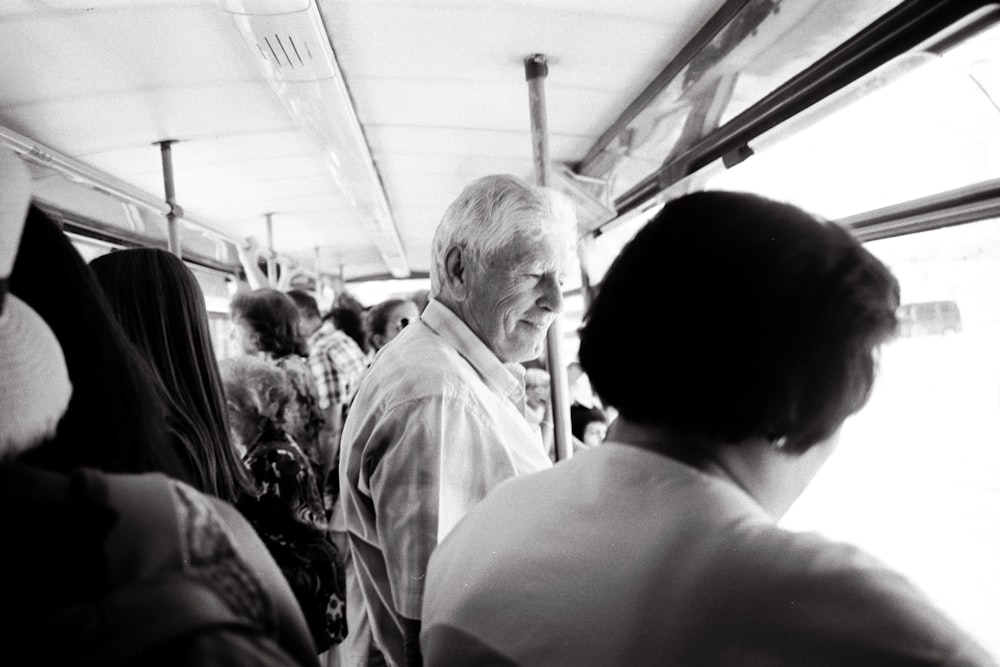 a black and white photo of a man on a bus