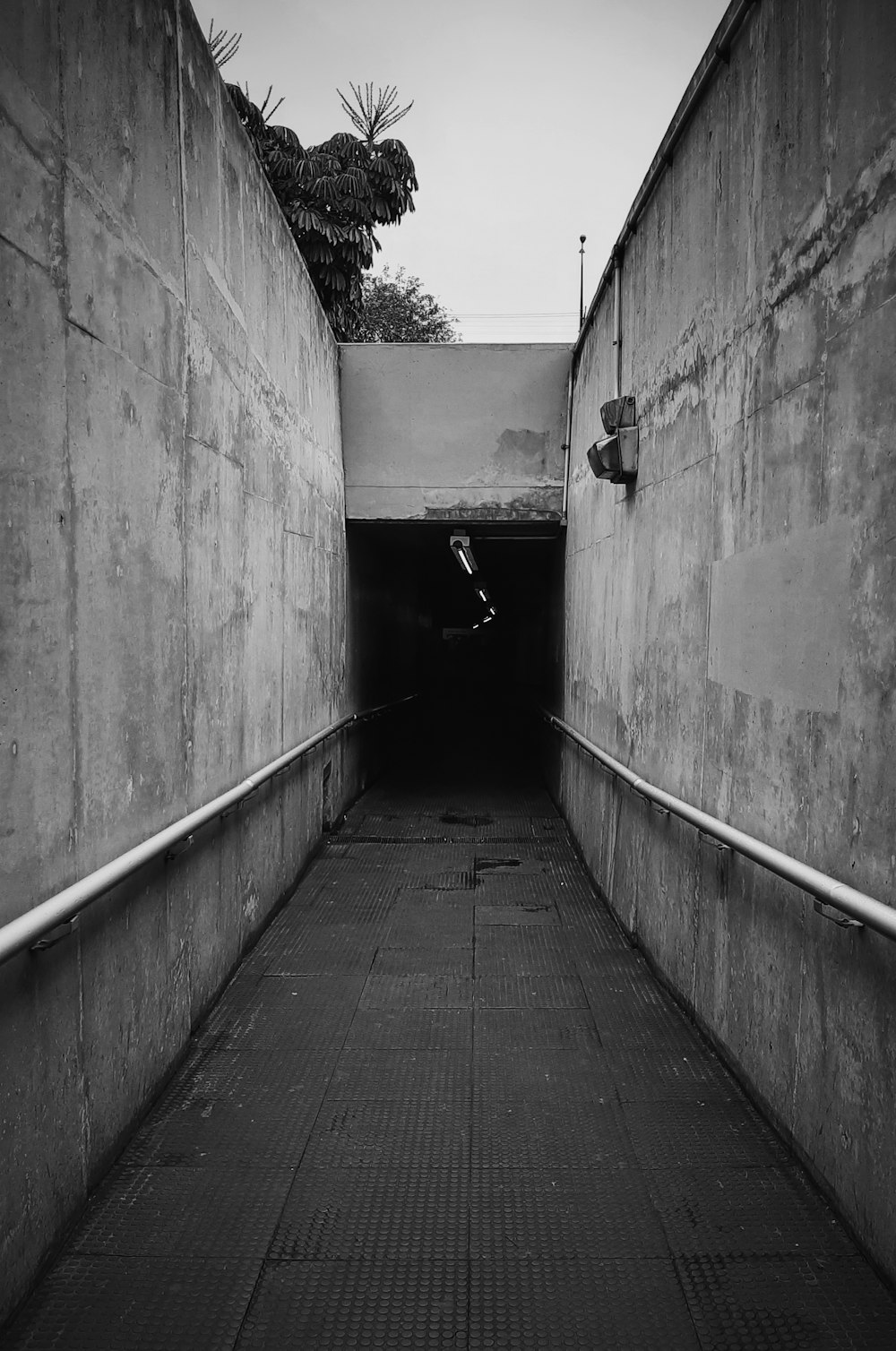 a black and white photo of a dark tunnel