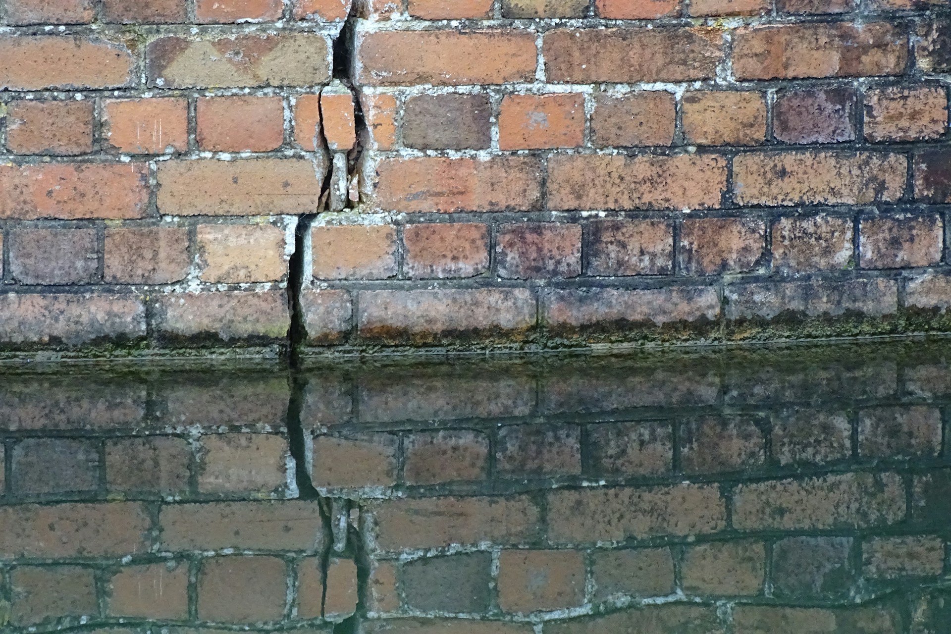 a brick wall next to a body of water