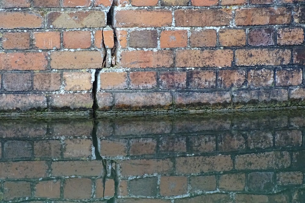 a brick wall next to a body of water