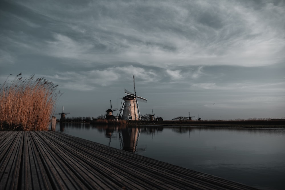 a windmill sitting next to a body of water