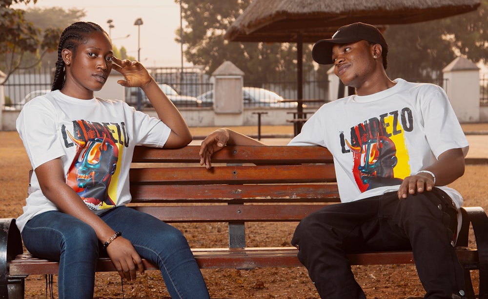 a couple of people sitting on top of a wooden bench