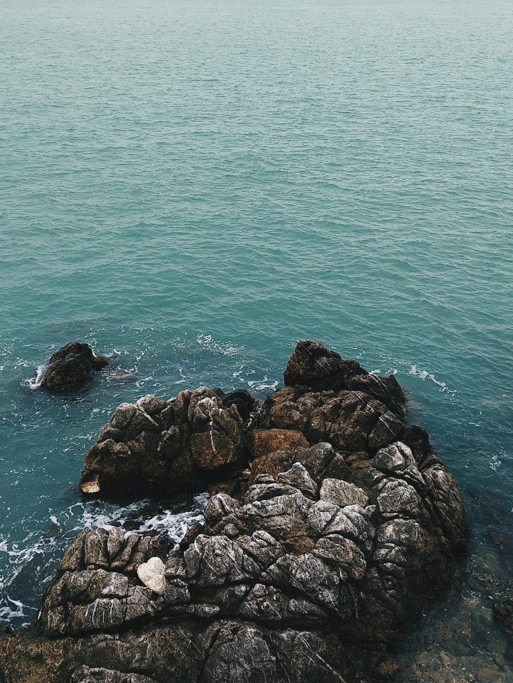 a couple of rocks sitting on top of a body of water