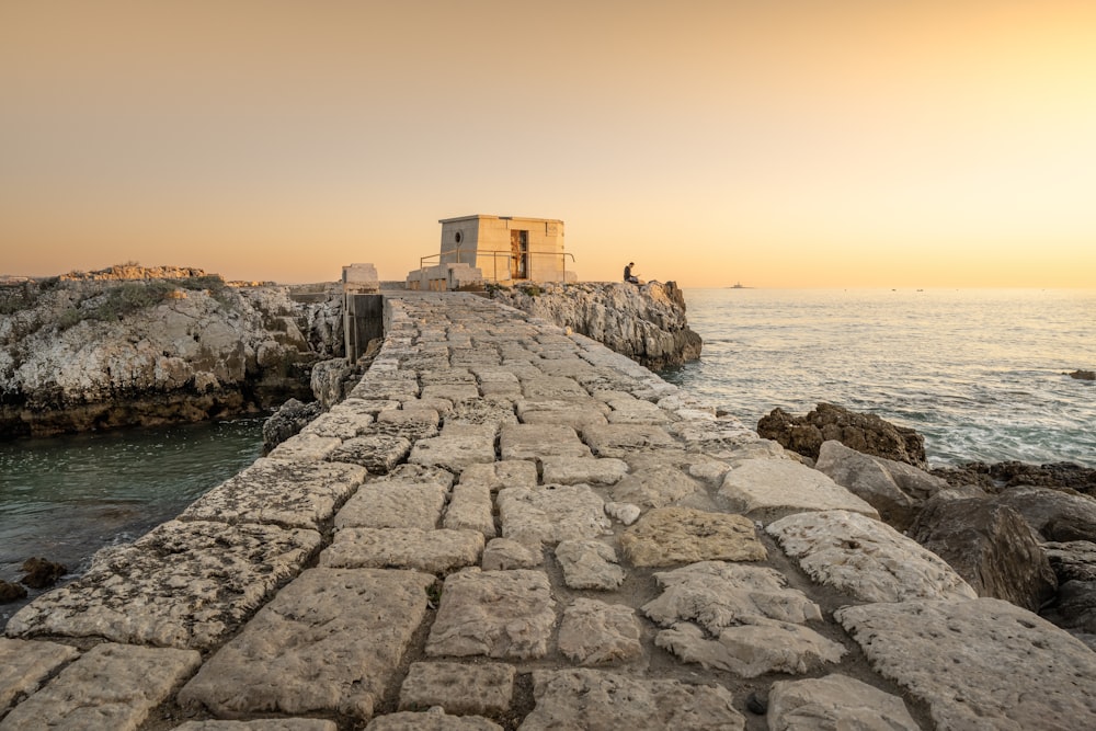 a stone walkway next to a body of water