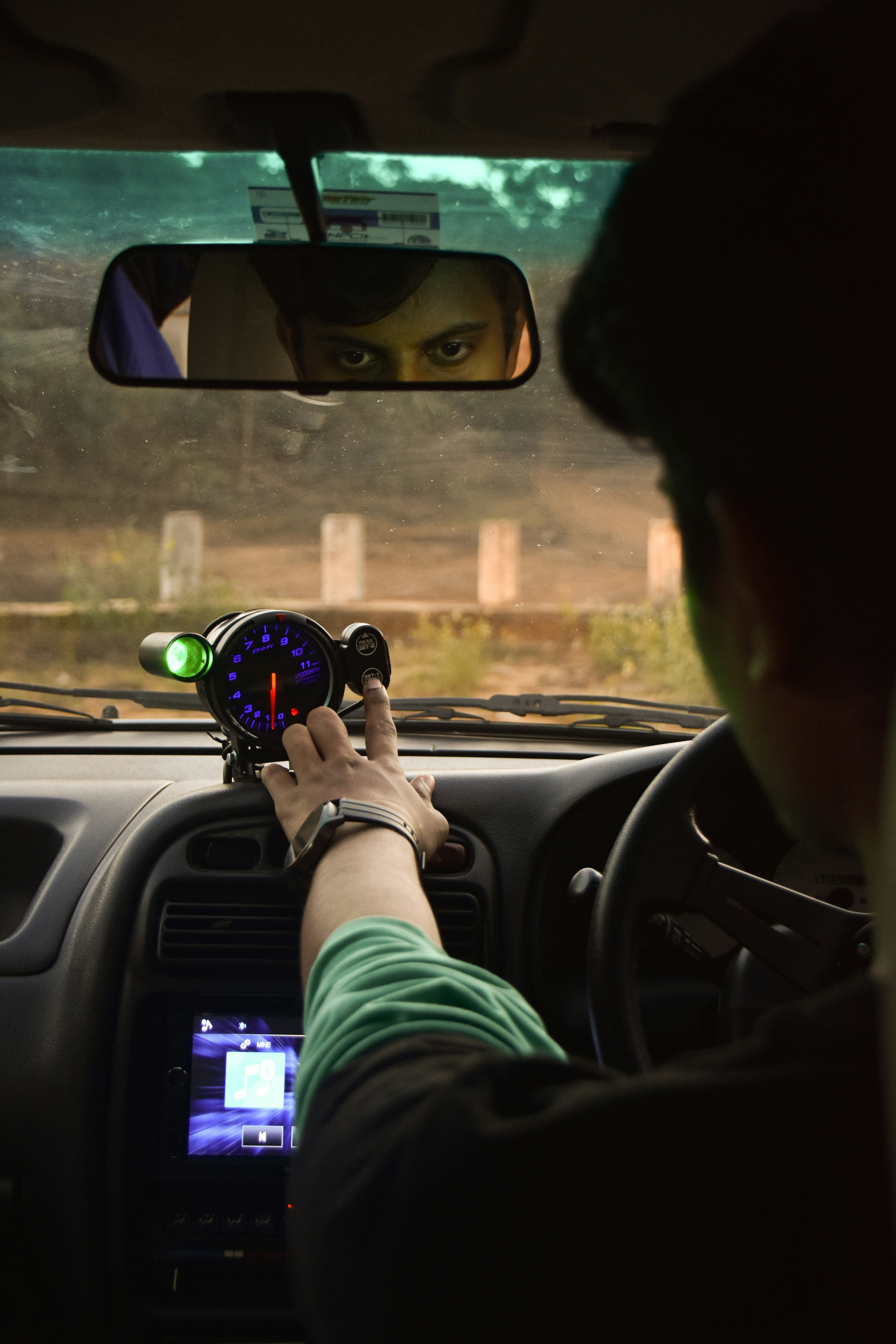 a man driving a car holding a steering wheel