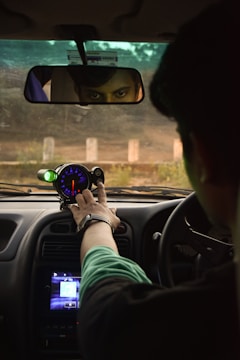 a man driving a car holding a steering wheel