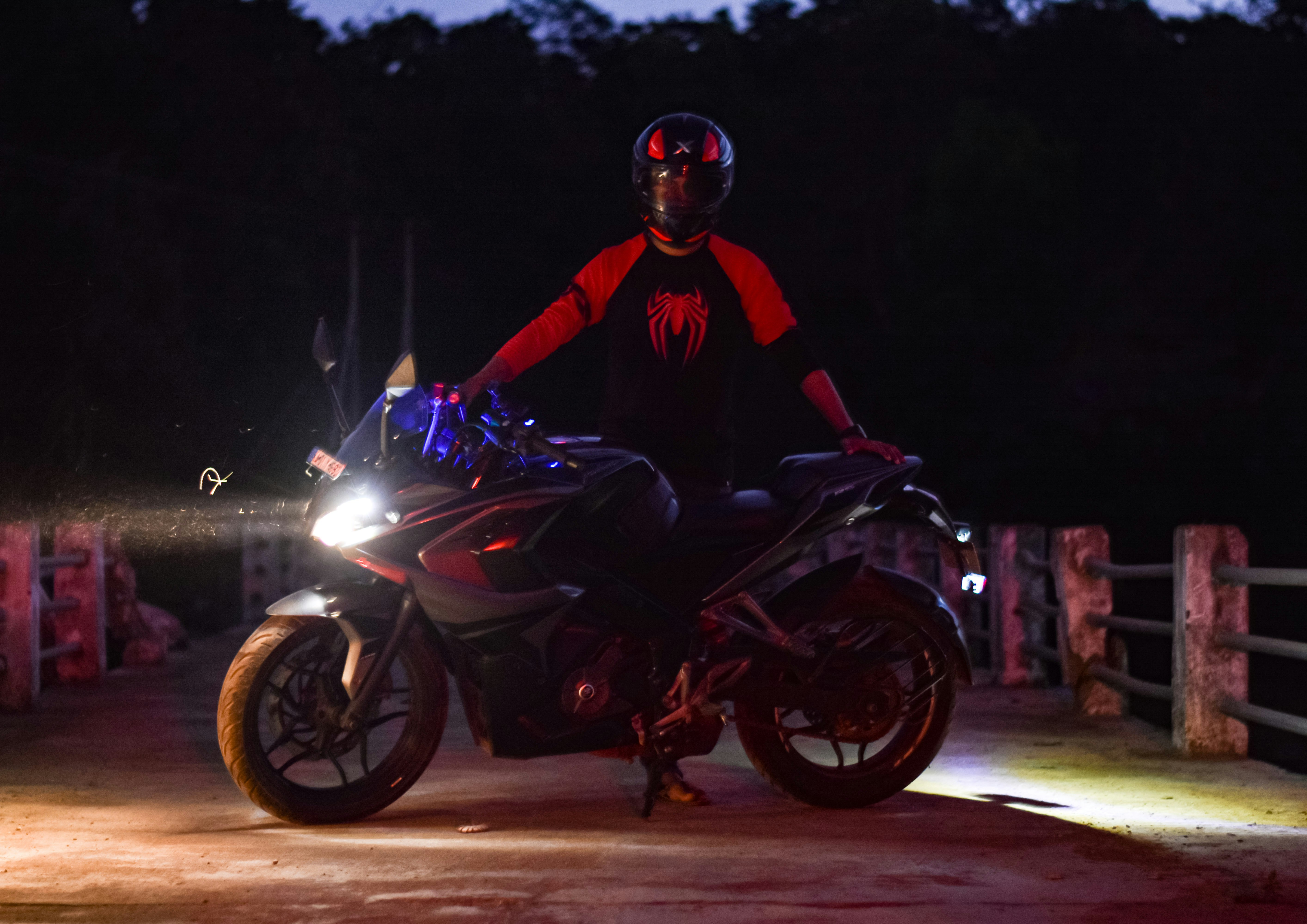 a man riding on the back of a motorcycle at night
