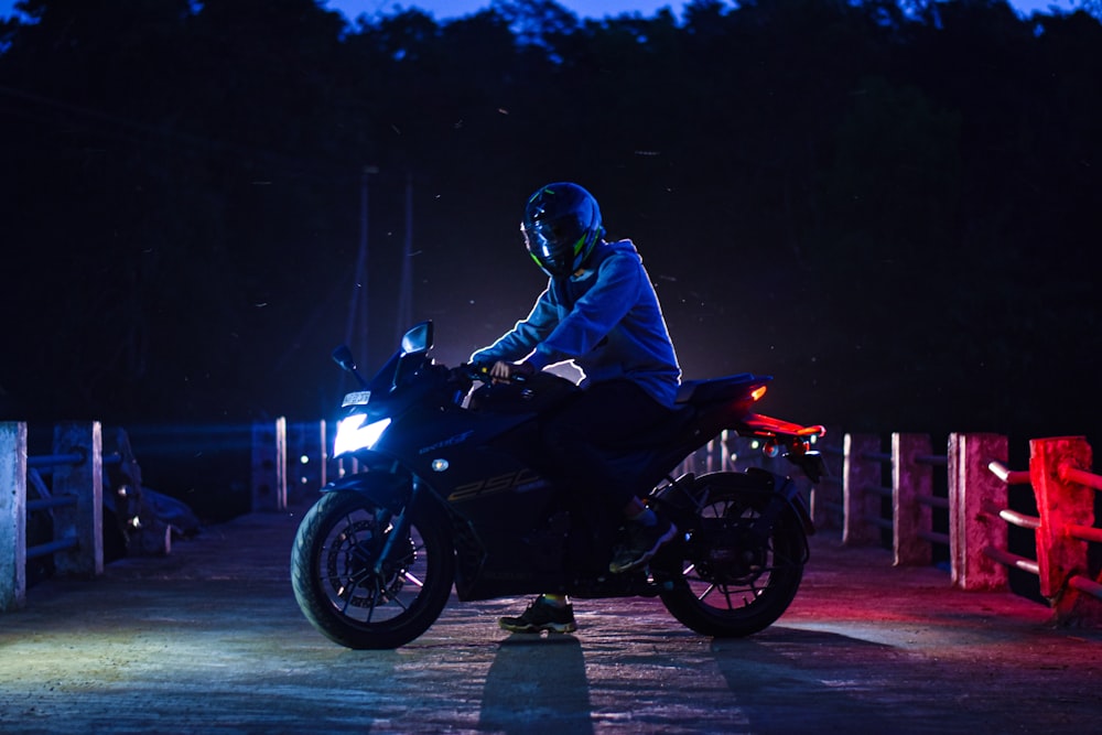 a person riding a motorcycle on a road at night