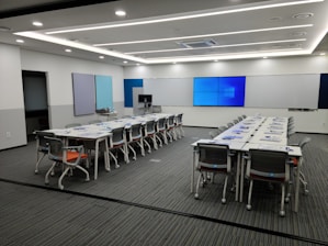 Spacious conference room with diverse professionals collaborating over digital devices.
