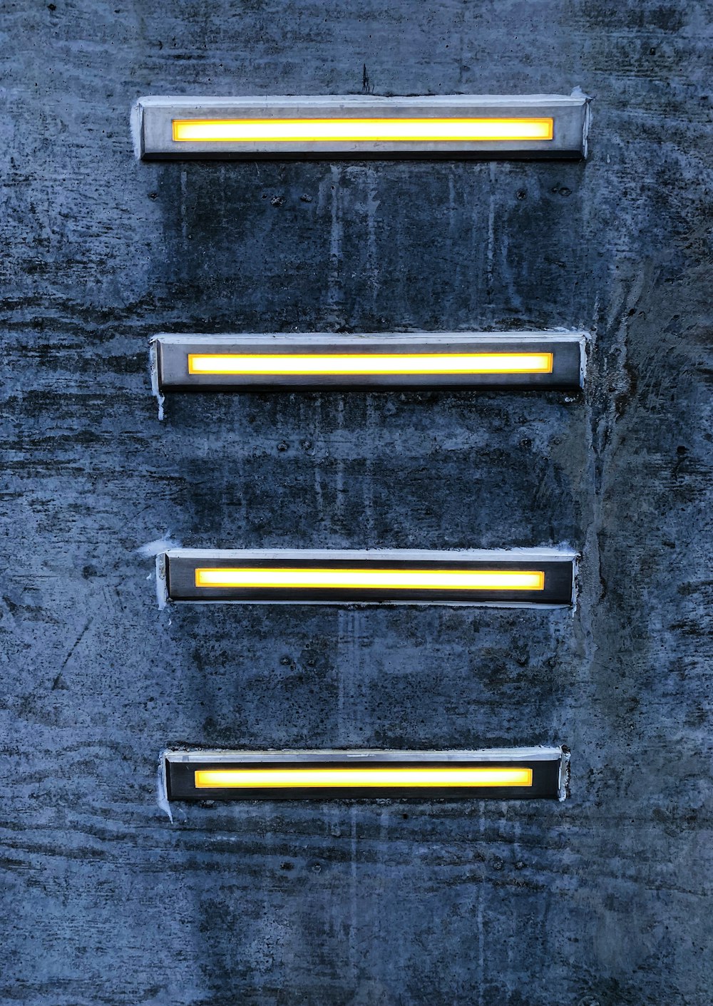 a set of three yellow lights on a wall