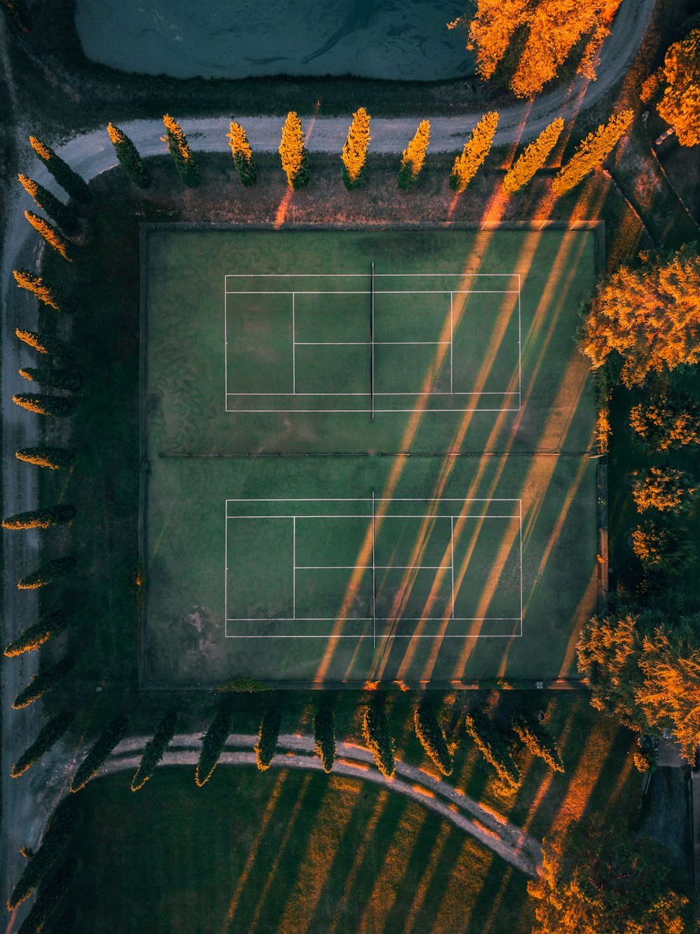 an aerial view of a tennis court surrounded by trees