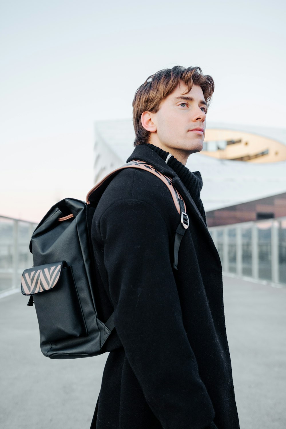 a man in a black coat with a black backpack