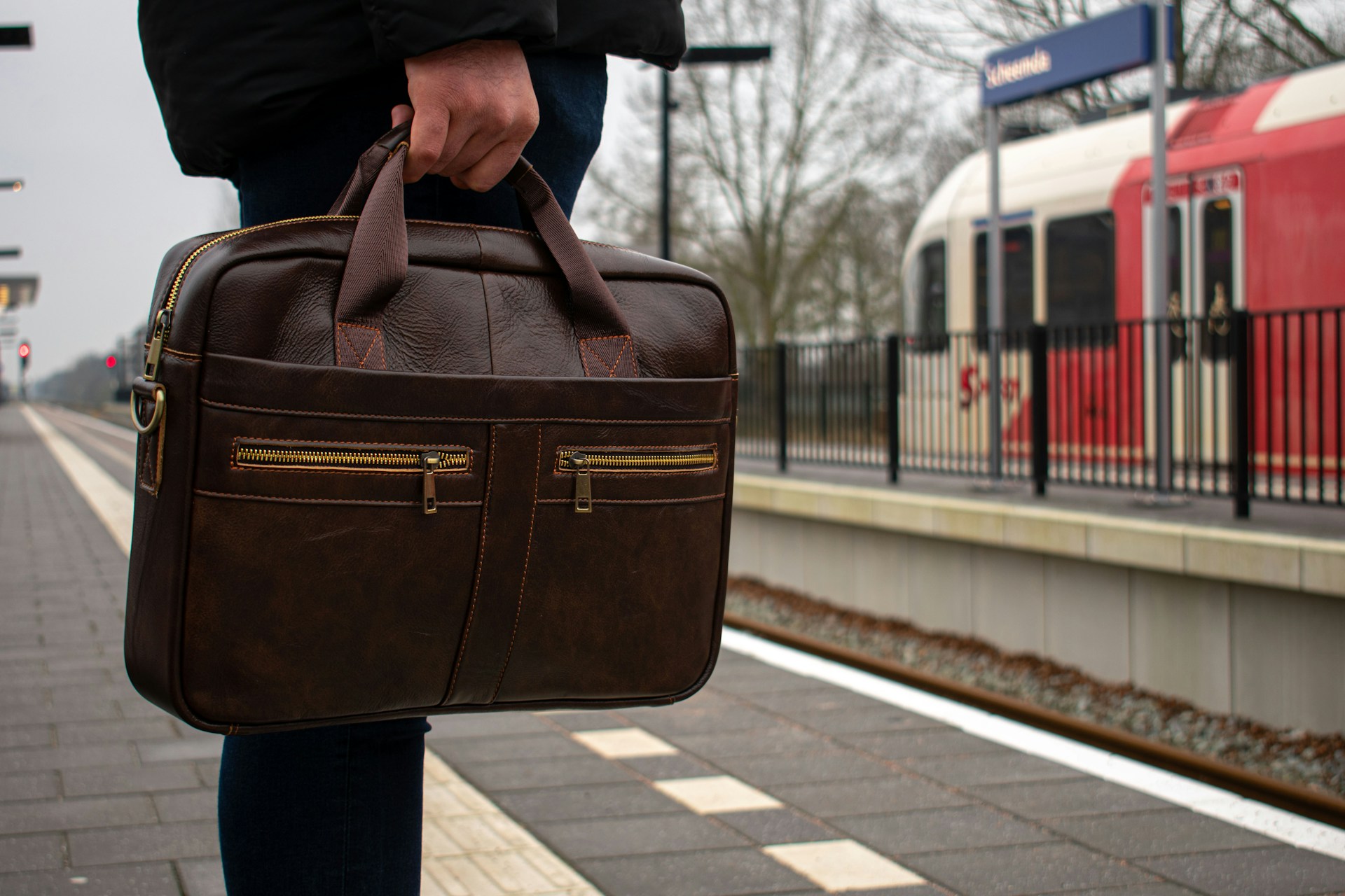 a man holding a briefcase on a train platform