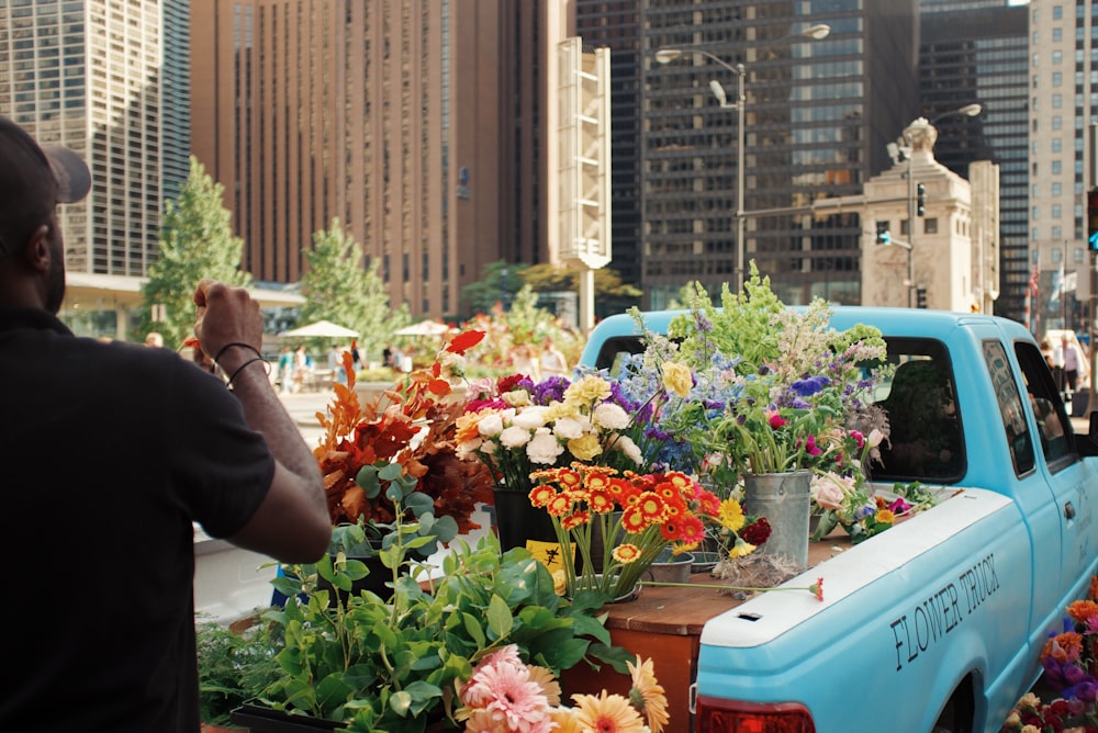 a man taking a picture of a truck with flowers in the bed