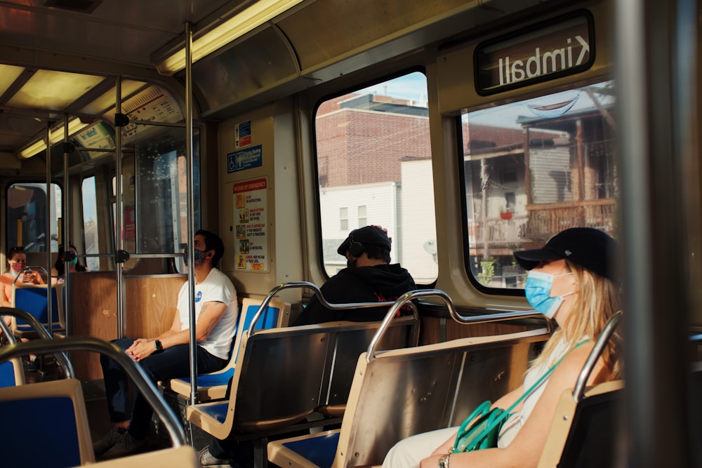 a group of people sitting on a train next to each other