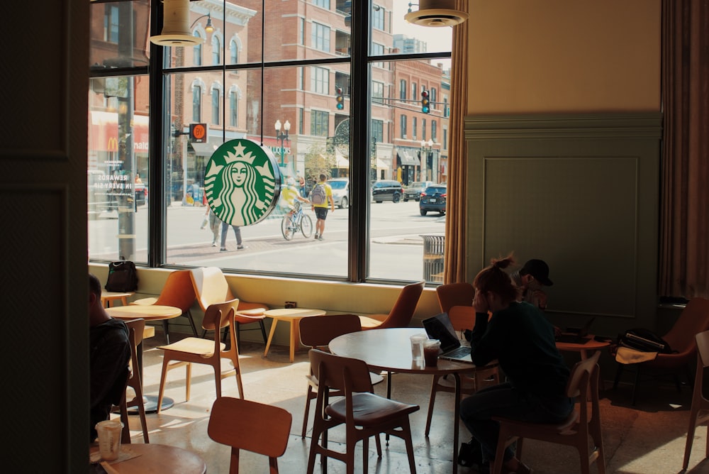 people sitting at tables in a starbucks coffee shop