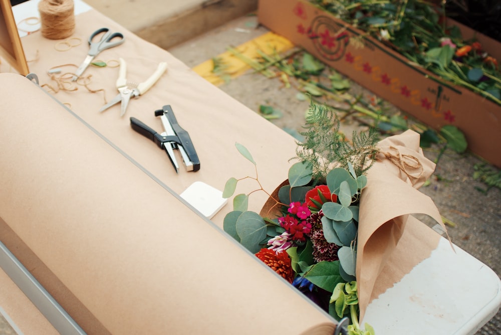 a table topped with lots of flowers and scissors