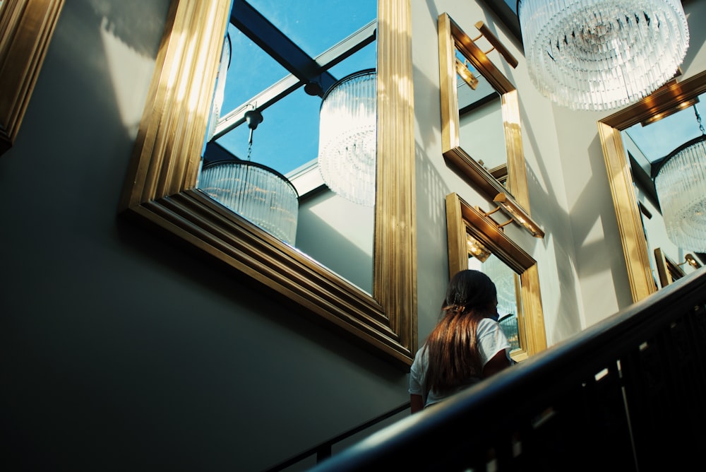 a woman standing in front of a mirror in a room