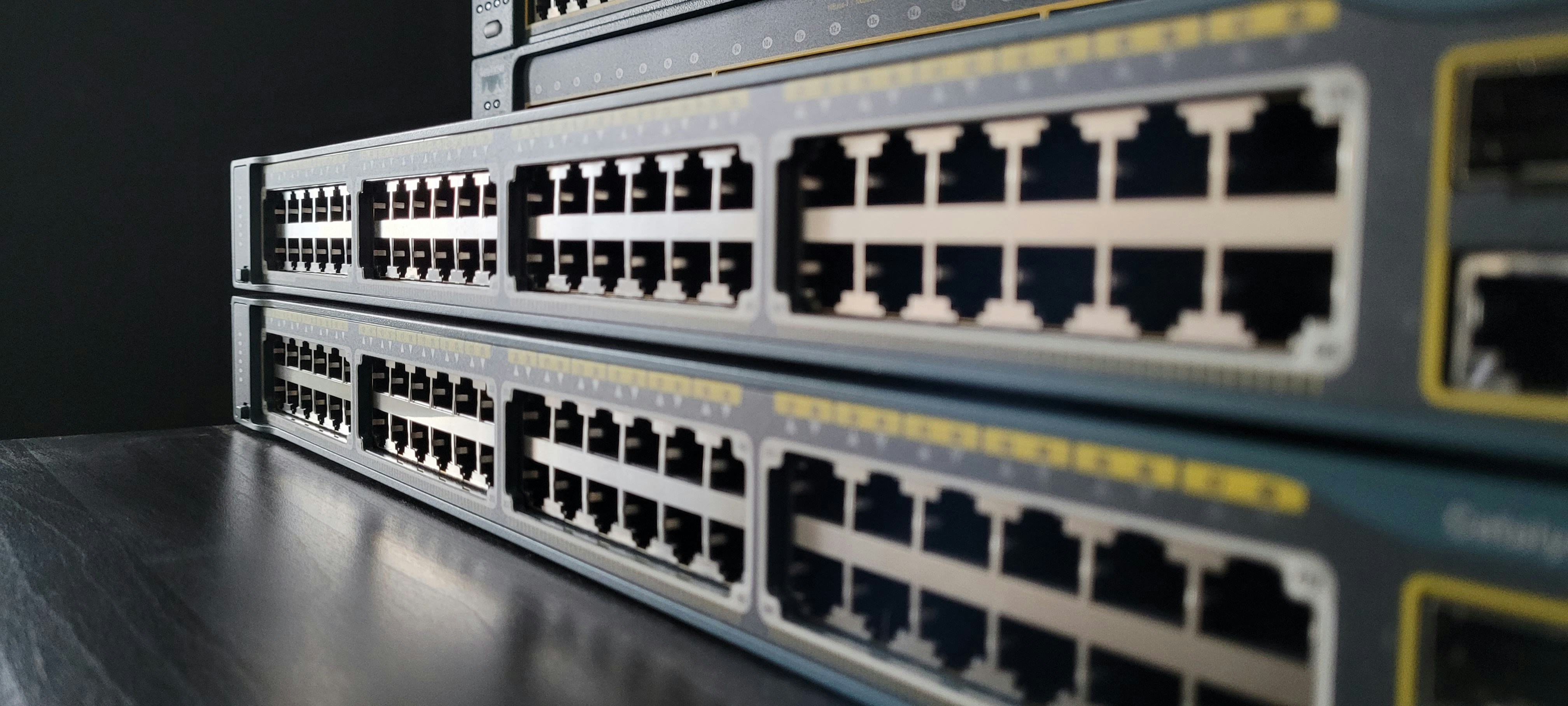 Cisco network switch with multiple ethernet ports and status LEDs, dark background