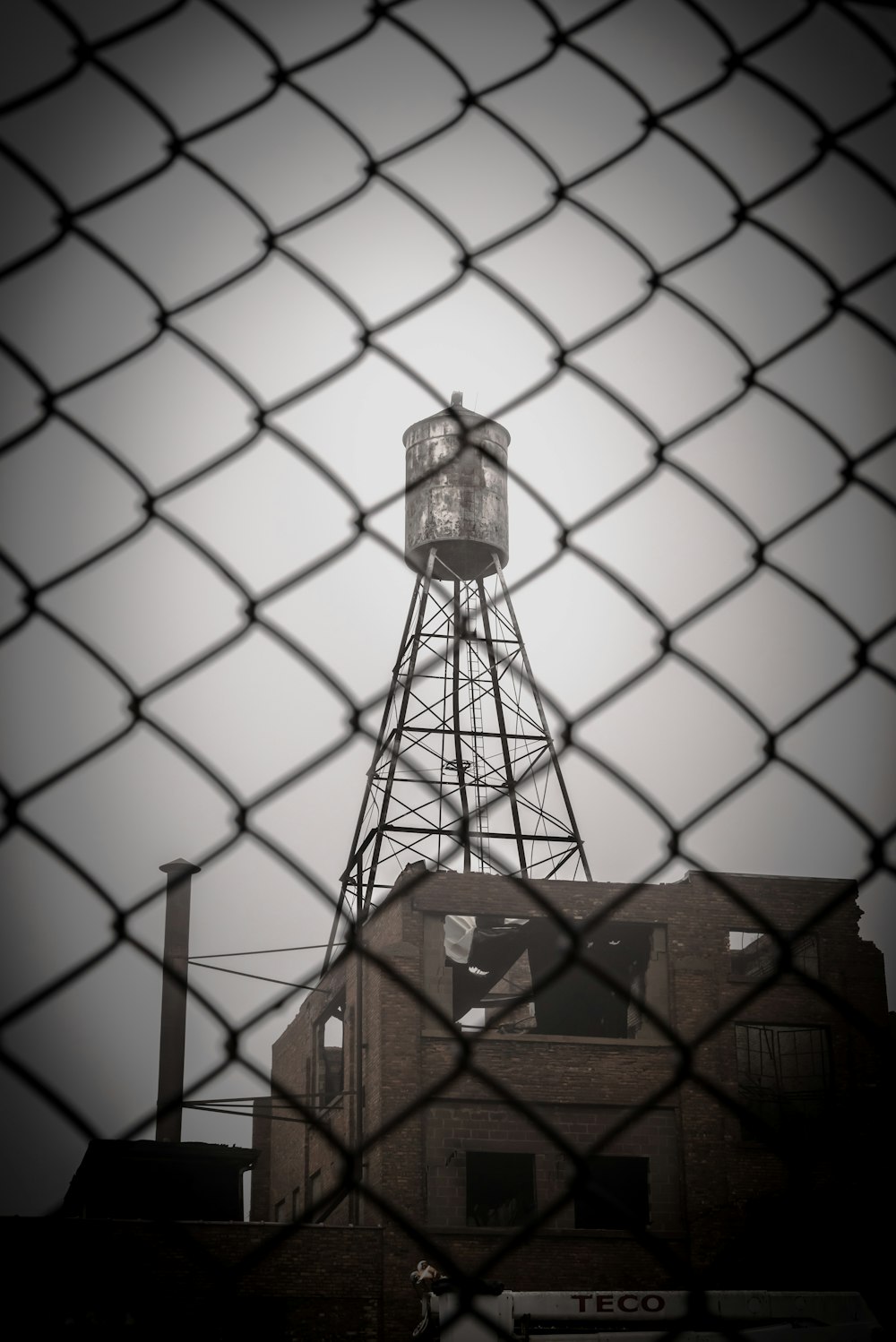 a water tower behind a chain link fence