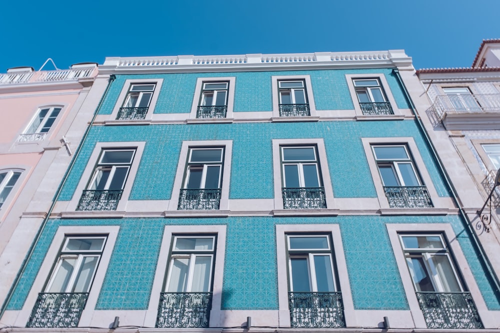 a blue building with many windows and balconies