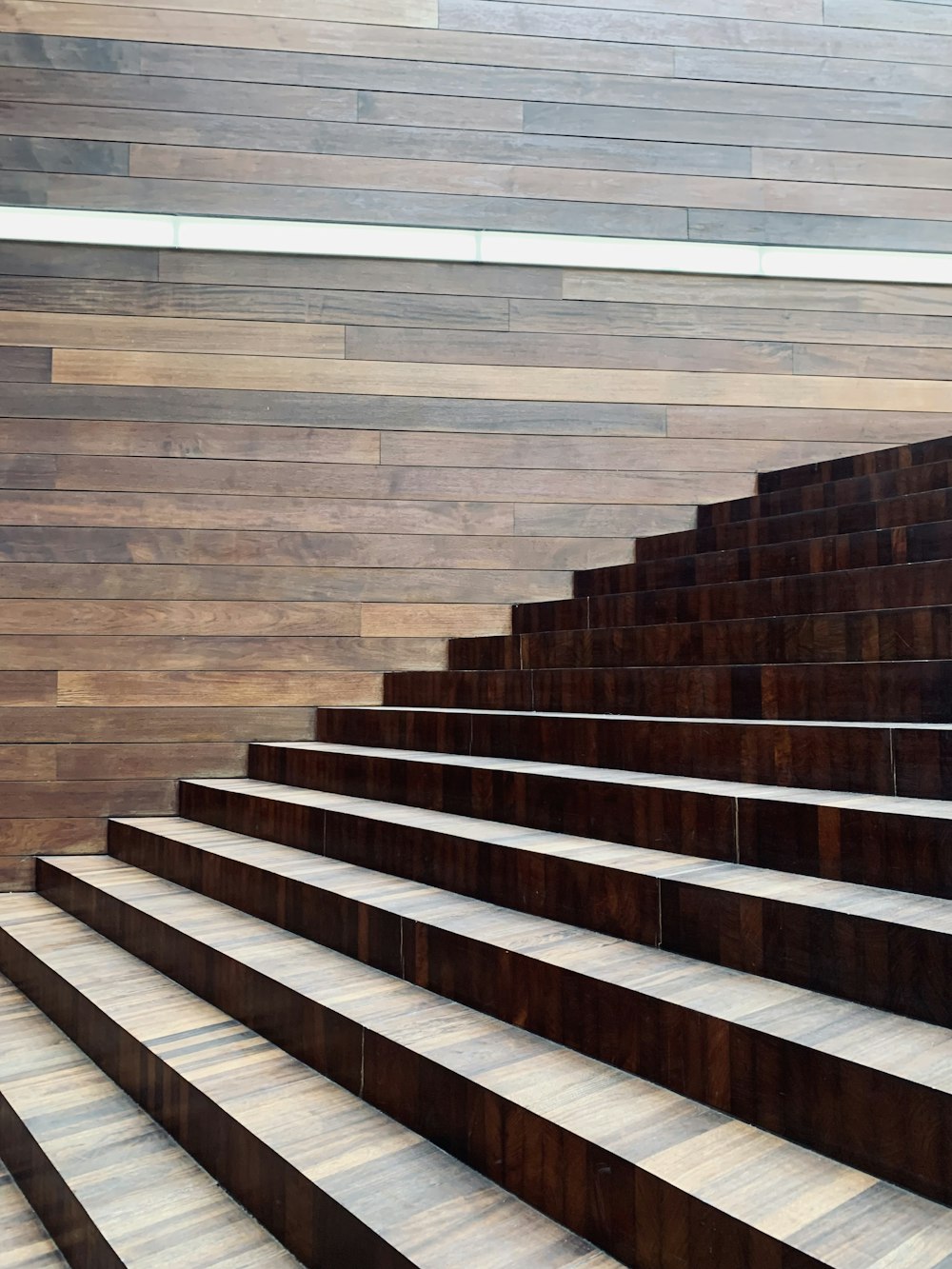 a set of wooden stairs in front of a wooden wall
