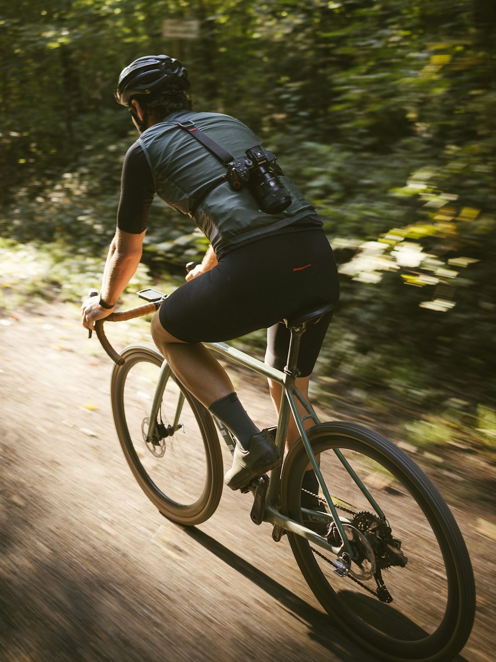 a man riding a bike down a dirt road