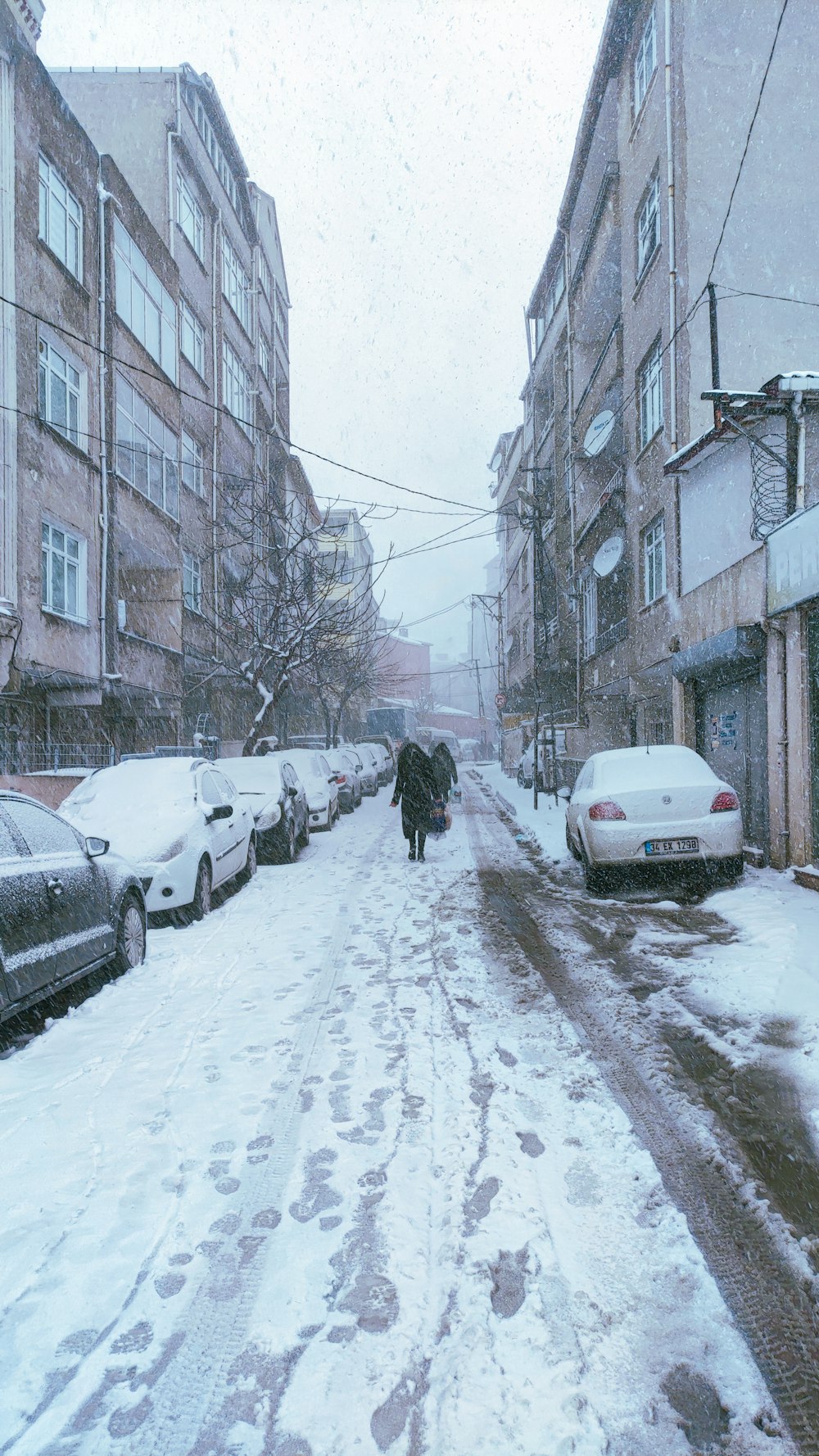 a person walking down a snow covered street