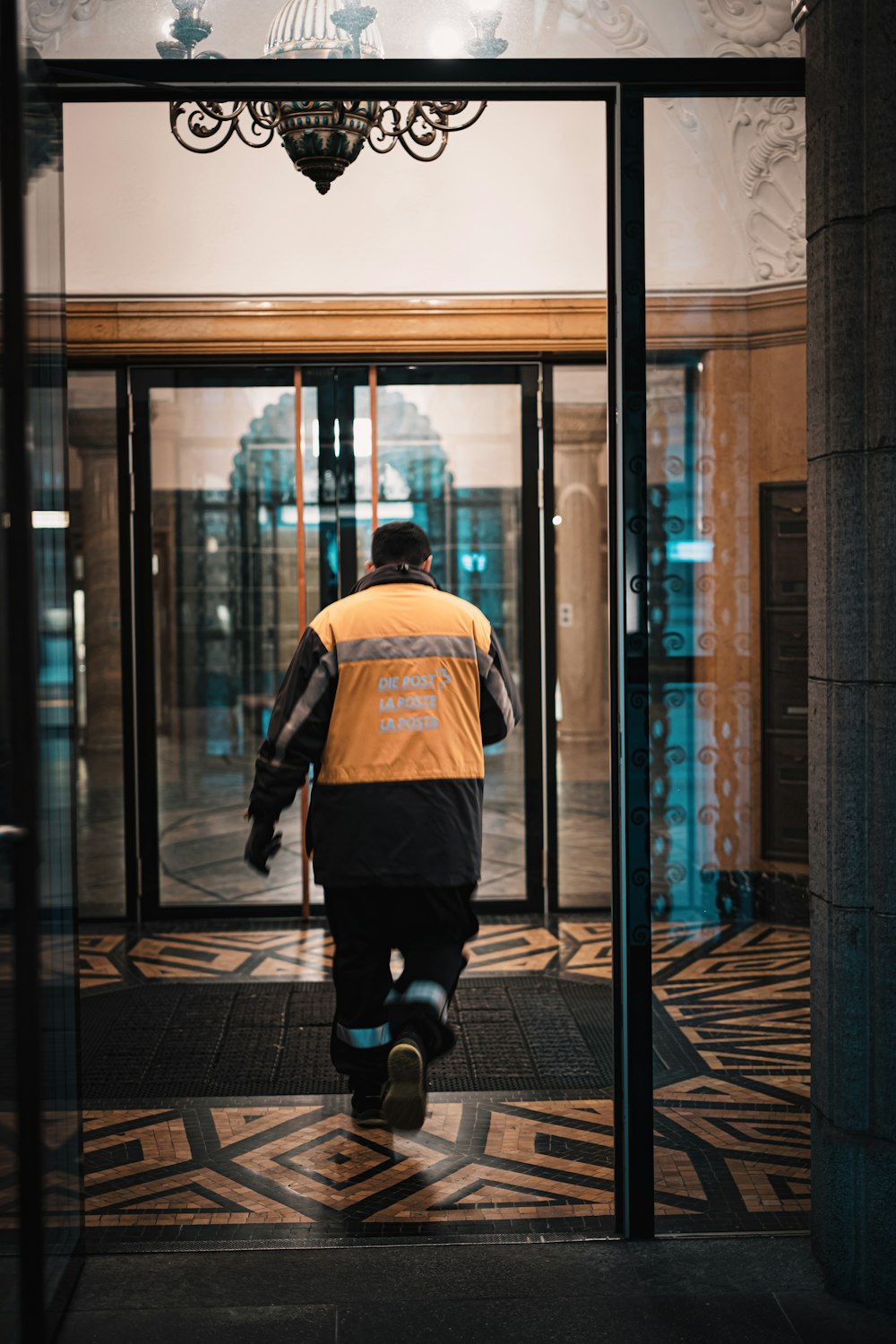 a man walking into a building through a glass door